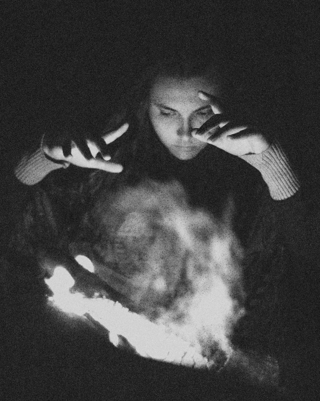 grayscale photo of woman standing in front of a smoke